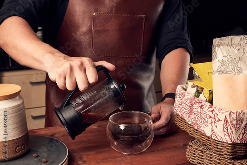 man who has just prepared a barista coffee is serving it in a hot cup