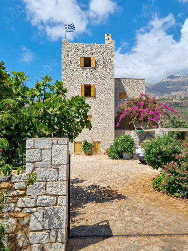 House of Limeni village with fishing boats in turquoise waters and the stone buildings as a background in Mani, Greece.