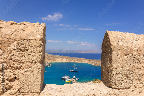 Panoramic view of colorful harbor in Lindos village, Rhodes. Aerial view of beautiful landscape, sea with sailboats and coastline of island of Rhodes in Aegean Sea. High quality photo