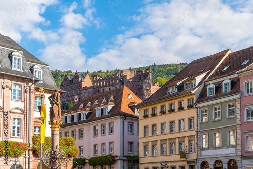 The medieval Heidelberg Castle is seen above the colorful buildings at Marktplatz, or Market Square in the medieval old town of Heidelberg, Germany.