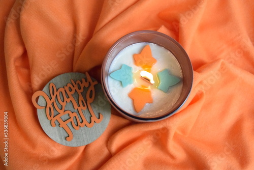 Happy Fall wood wick candle with maple leaves on orange scarf. 