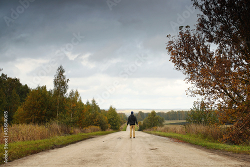 Man on empty road and autumn nature around and grey sky. Pavel Kubarkov, i on empty road. Photo was taken 1 October 2022 year, MSK time in Russia.