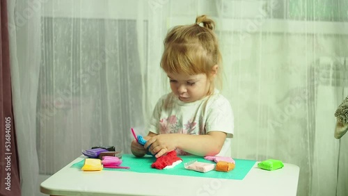 a little girl enthusiastically plays with plasticine, the development of motor skills and sensory skills of hands