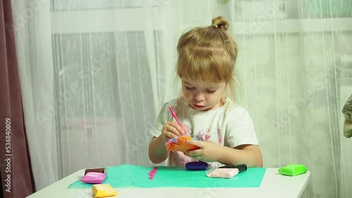 a little girl enthusiastically plays with plasticine, the development of motor skills and sensory skills of hands
