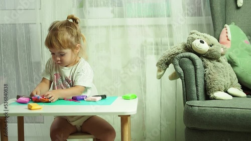 a little girl enthusiastically plays with plasticine, the development of motor skills and sensory skills of hands