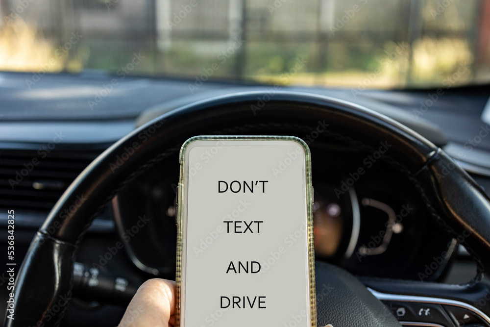 dont text and drive, mobile phone held whilst driving car, danger concept, copy space