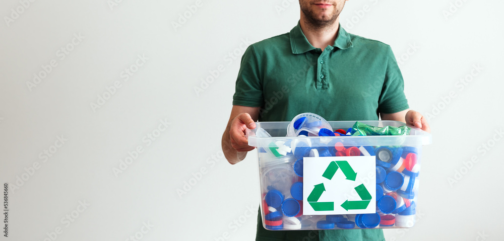 recycling, waste sorting and sustainability concept. man holding container with recycling plastic waste. banner with copy space recycling, waste sorting and sustainability concept. man holding container with recycling plastic waste. banner with copy space