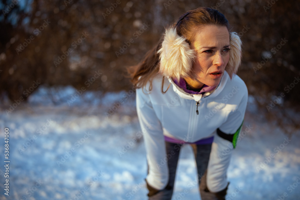 tired woman in jacket catching breath after exercise tired woman in jacket catching breath after exercise