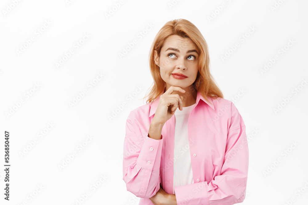 Portrait of young woman thinking, looking curious, standing over white background Portrait of young woman thinking, looking curious, standing over white background