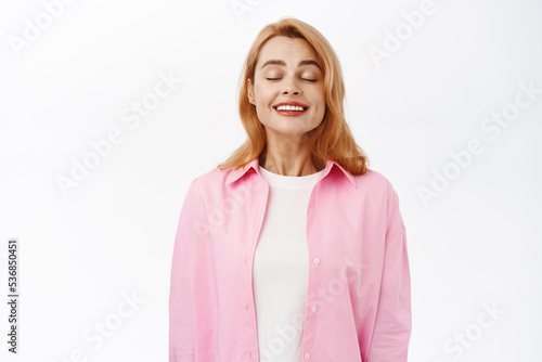 Portrait of beautiful happy woman showing healthy white smile  standing over white background
