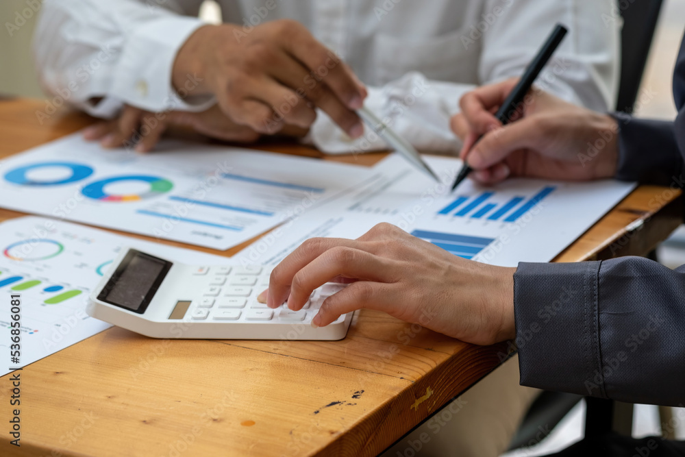 The company's team of marketers analyzes the company's profits using laptop computer graphs and calculators. The company's team of marketers analyzes the company's profits using laptop computer graphs and calculators.