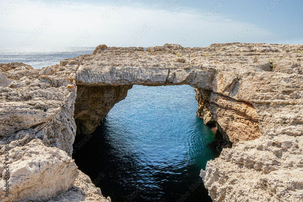 Puente de piedra natural en menorca con mar mediterraneo