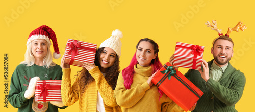 Different people with Christmas gifts on yellow background