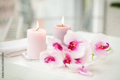 Orchids and burning aromatic candles on spa salon