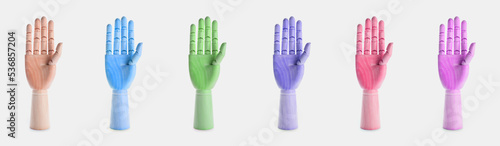 Collection of colorful mannequin hands on light background
