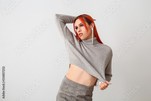 Stylish transgender woman on light background photo