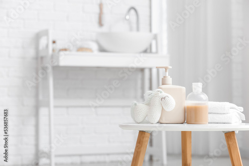 Different bath supplies for children and toys on white table in light bathroom