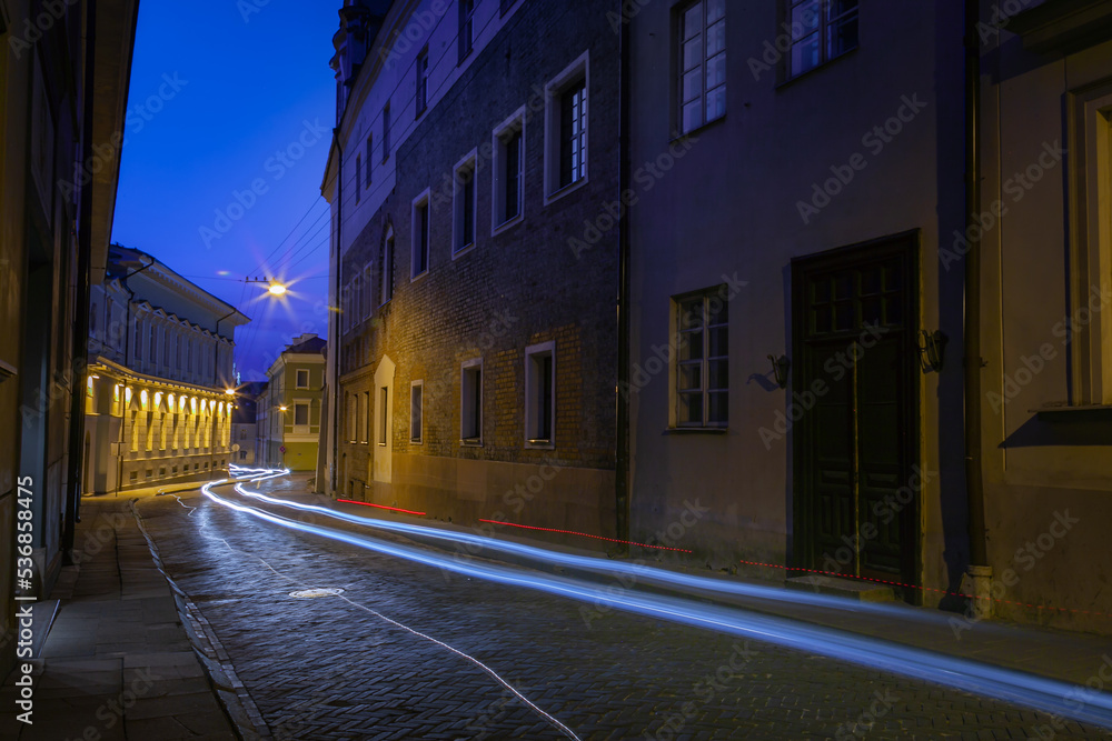 Street and luminous track from the car at night in Vilnius Old Town, Lithuania