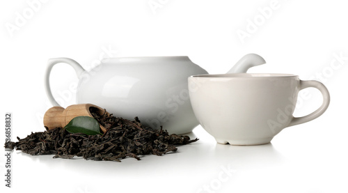 Scoop of dry puer tea with cup and teapot on white background
