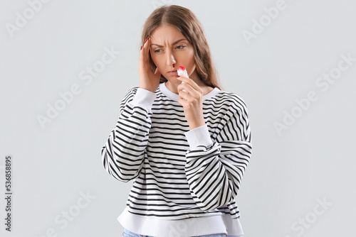 Young woman with nosebleed ...