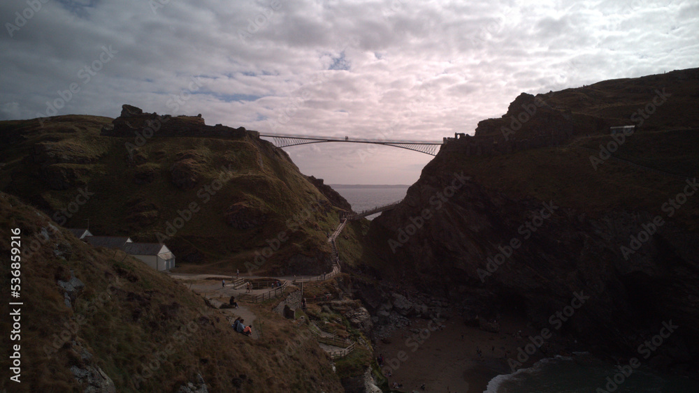 drone footage of a bridge in Cornwall over a beach cove