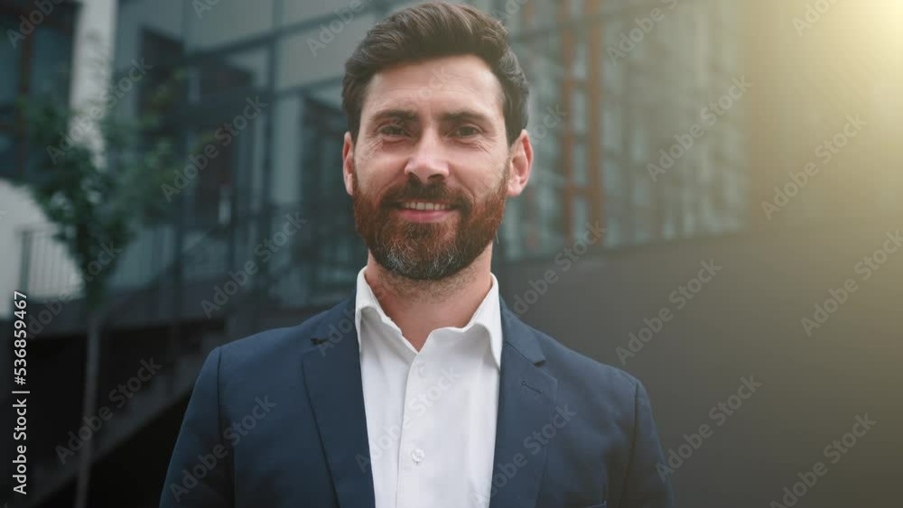 Elegant successful caucasian businessman wearing formal suit happy male portrait of adult 30s employee bearded middle eastern attractive man posing outdoors modern city office background in sunny day Elegant successful caucasian businessman wearing formal suit happy male portrait of adult 30s employee bearded middle eastern attractive man posing outdoors modern city office background in sunny day