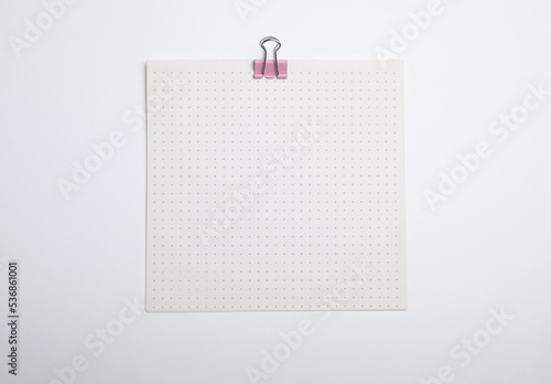 Sheet of paper with clip on white background, top view