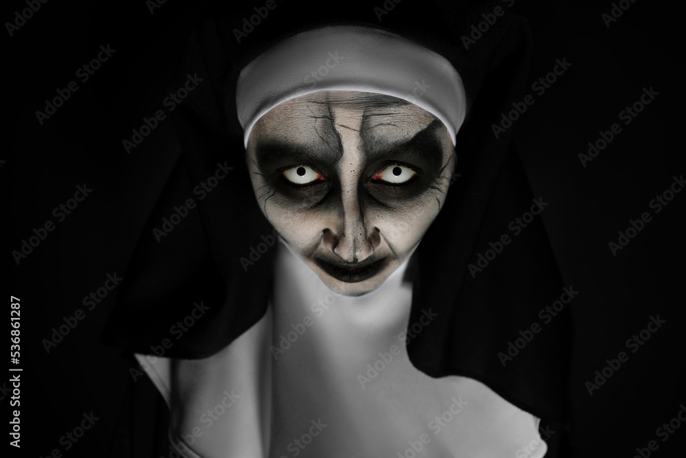 Portrait of scary devilish nun on black background. Halloween party look Portrait of scary devilish nun on black background. Halloween party look
