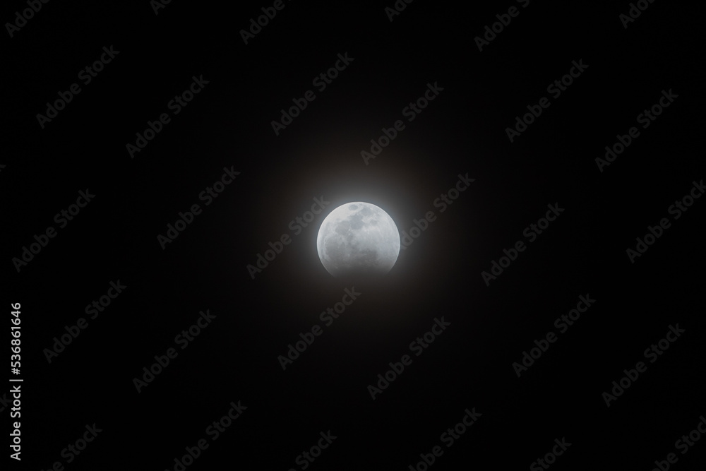 Lunar eclipse stage 2, January 20, 2019 at 8:45 pm pacific time in San Diego, CA. The total lunar eclipse started at 8:41 p.m. The moon begins its journey to the dark inner part of the earth's shadow. - obrazy, fototapety, plakaty 