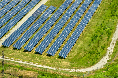 Aerial view of big sustainable electric power plant with many rows of solar photovoltaic panels for producing clean electrical energy. Renewable electricity with zero emission concept
