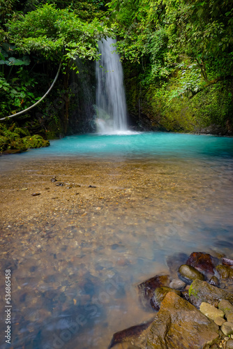 Curug Cipondok of Subang west Java Indonesia. Jungle waterfall cascade in tropical rainforest with rock and turquoise blue pond. 