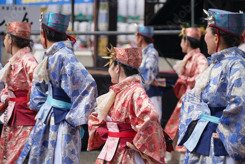 Ikebukuro, Tokyo / Japan - October 8 2022: Crowd of Yosakoi dancers wearing blue and red costumes performing in the streets during Tokyo Yosakoi festival.
