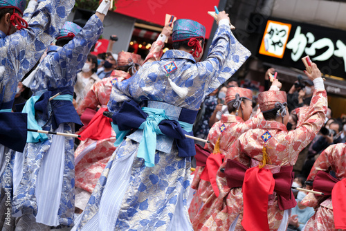 Ikebukuro, Tokyo / Japan - October 8 2022: Crowd of Yosakoi dancers wearing blue and red costumes performing in the streets during Tokyo Yosakoi festival.