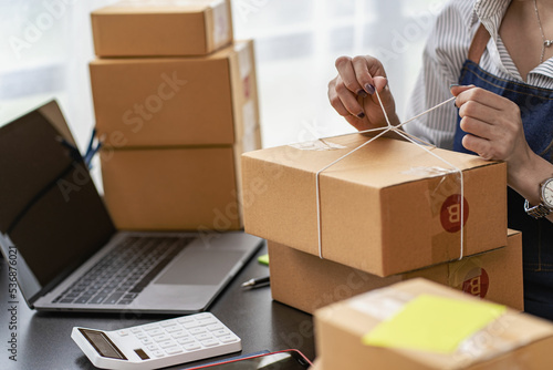 Operators work on receiving boxes and check online orders to prepare the packaging. Sell ​​to customers. SME business concept online e-commerce © ArLawKa