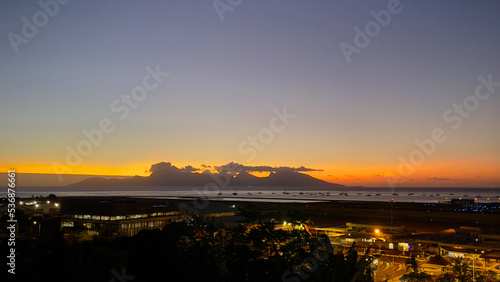 Sunset behind Moorea Island with Faa'a International Airport in the foreground at night © Harriet