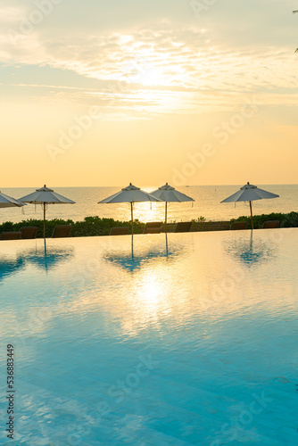 umbrella with bed pool around swimming pool with ocean sea background © topntp