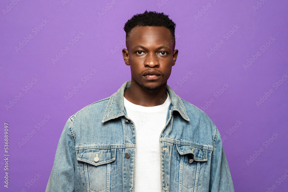 Obraz premium Portrait of young handsome African man face looking at camera in purple color studio isolated background