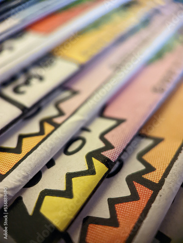 Closeup view of an old comic book collection stacked in a pile creates colorful background paper texture with abstract shapes