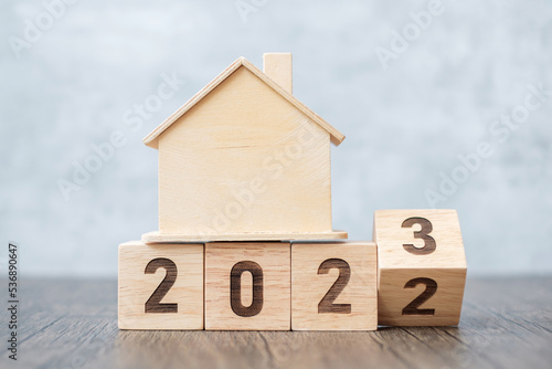 flip 2022 to 2023 block with house model. real estate, Home loan, tax, investment, financial, savings and New Year Resolution concepts photo