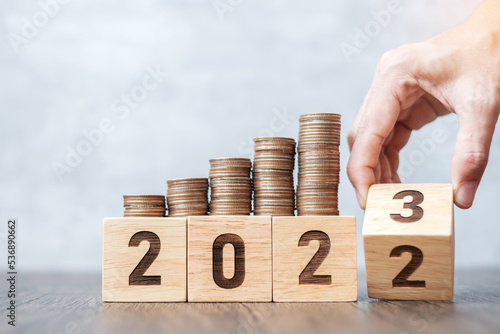 flipping 2022 to 2023 year block with Coins stack. Money, Budget, tax, investment, financial, savings and New Year Resolution concepts