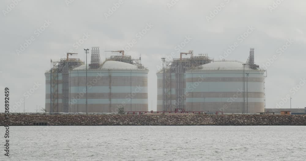 4K Zoom shot of a liquefied natural gas terminal with a truck passing by in a cloudy day in autumn in Sagunto, Spain. Slow motion 60fps 4K Zoom shot of a liquefied natural gas terminal with a truck passing by in a cloudy day in autumn in Sagunto, Spain. Slow motion 60fps
