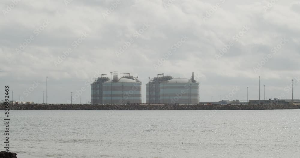 4K Timelapse shot of a liquefied natural gas terminal in a cloudy day by the sea in autumn in Sagunto, Spain. 4K Timelapse shot of a liquefied natural gas terminal in a cloudy day by the sea in autumn in Sagunto, Spain.