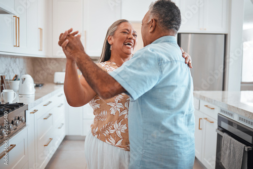 Fototapeta Happy senior couple, dance and laughing in joyful happiness for relationship bonding in the kitchen at home