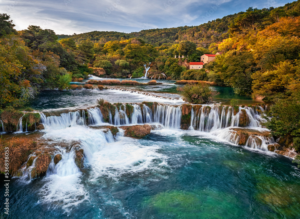 Krka, Croatia - Aerial view of the famous Krka Waterfalls in Krka National Park on a bright autumn morning with colorful autumn foliage, turquoise water and blue sky