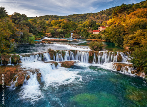 Krka, Croatia - Aerial view of the famous Krka Waterfalls in Krka National Park on a bright autumn morning with colorful autumn foliage, turquoise water and blue sky