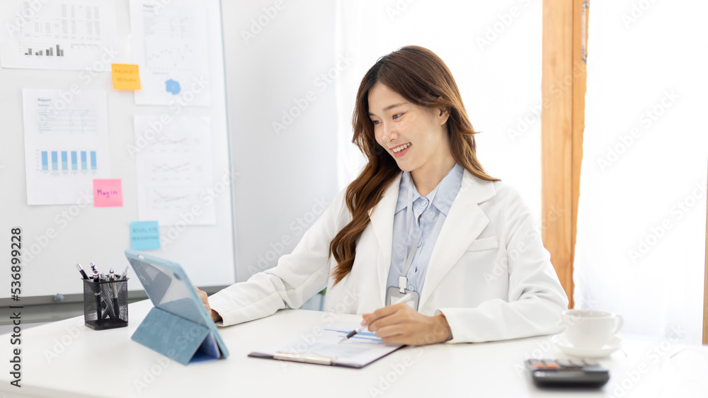 Businesswoman using laptop to work, Asian woman working in the office, Financial clerk or accountant with documents and equipment working on the desk, Using tablet for financial transactions. Businesswoman using laptop to work, Asian woman working in the office, Financial clerk or accountant with documents and equipment working on the desk, Using tablet for financial transactions.