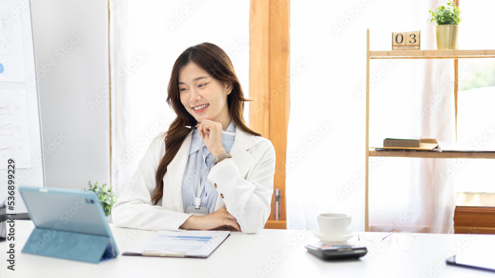 Businesswoman using laptop to work, Asian woman working in the office, Financial clerk or accountant with documents and equipment working on the desk, Using tablet for financial transactions. Businesswoman using laptop to work, Asian woman working in the office, Financial clerk or accountant with documents and equipment working on the desk, Using tablet for financial transactions.