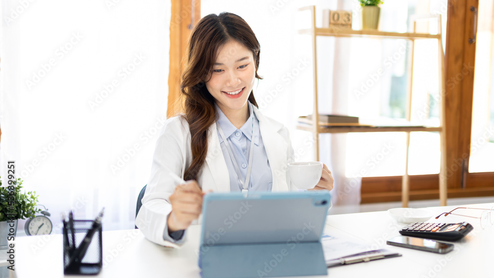 Businesswoman using laptop to work, Asian woman working in the office, Financial clerk or accountant with documents and equipment working on the desk, Using tablet for financial transactions. Businesswoman using laptop to work, Asian woman working in the office, Financial clerk or accountant with documents and equipment working on the desk, Using tablet for financial transactions.