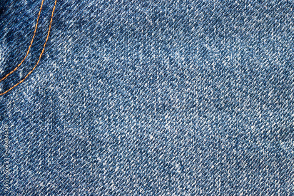 Jeans texture of blue cotton fabric with yellow threads. Close up Jeans texture of blue cotton fabric with yellow threads. Close up