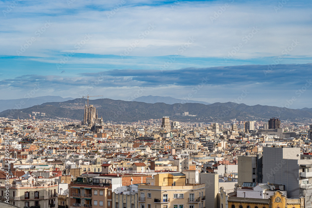 Cityscape of Barcelona with blue sky and mountains on background. Vacation and travel concept 